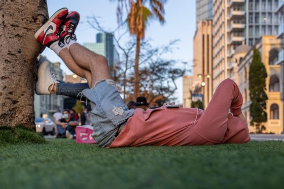 Couple détendu assis dans l'herbe au coucher du soleil