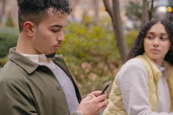 Femme regardant son compagnon sur son telephone avec inquietude, jalousie dans le couple