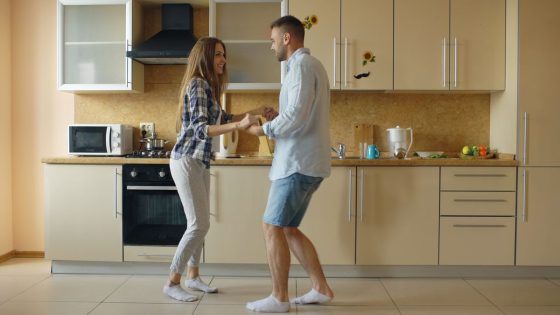 Couple complice qui danse dans sa cuisine